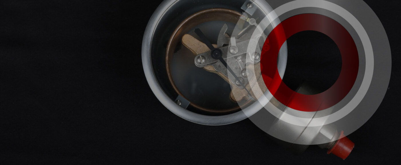 Close-up of a mechanical pressure gauge component showing internal metal mechanisms